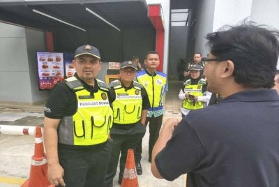 Muhamad Hanif (kiri) ketika melakukan pemantauan di salah sebuah stesen minyak baru-baru ini.