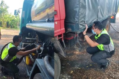 Anggota KPDN memeriksa lori yang ditahan ketika operasi. Foto KPDN