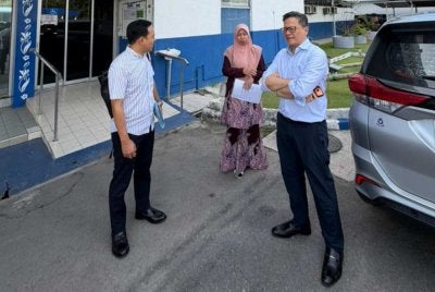 Noraidah (tengah) bersama pasukan peguam yang mewakilinya membuat laporan polis di Balai Polis Karamunsing.