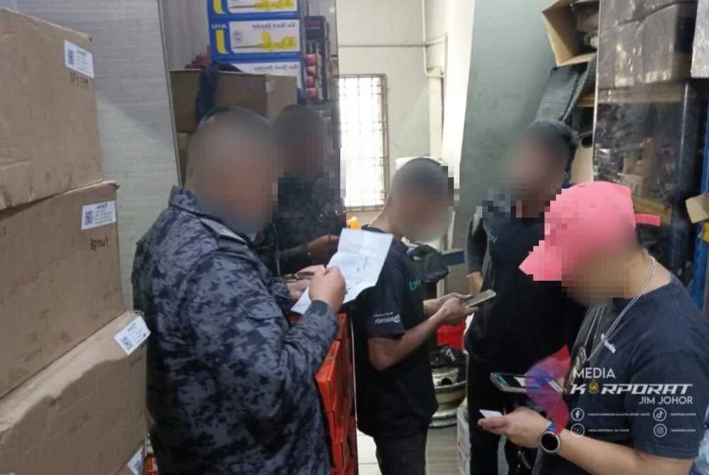 Pegawai Imigresen memeriksa dokumen warga asing ketika serbuan di premis perniagaan. Foto: JIM Johor