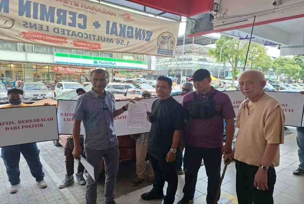 Faizan (kanan) dan beberapa orang awam menyampaikan memorandum kepada wakil Rafizi di depan pejabat Invoke Solution di sini, hari ini.