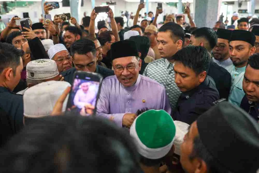 Anwar beramah mesra dengan jemaah selepas menunaikan solat Jumaat di Masjid Nurussaadah Kampung Cheras Baru, Cheras, pada Jumaat. Foto Bernama