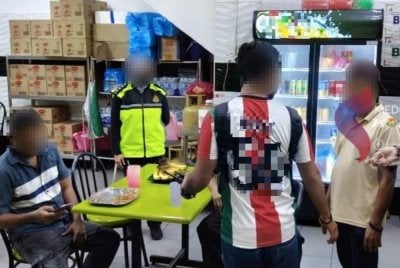 Pegawai Imigresen memeriksa dokumen warga asing ketika serbuan di premis perniagaan. Foto: JIM Johor