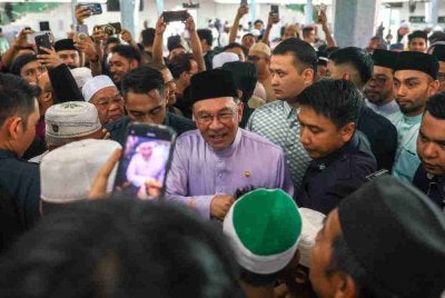 Anwar beramah mesra dengan jemaah selepas menunaikan solat Jumaat di Masjid Nurussaadah Kampung Cheras Baru, Cheras, pada Jumaat. Foto Bernama