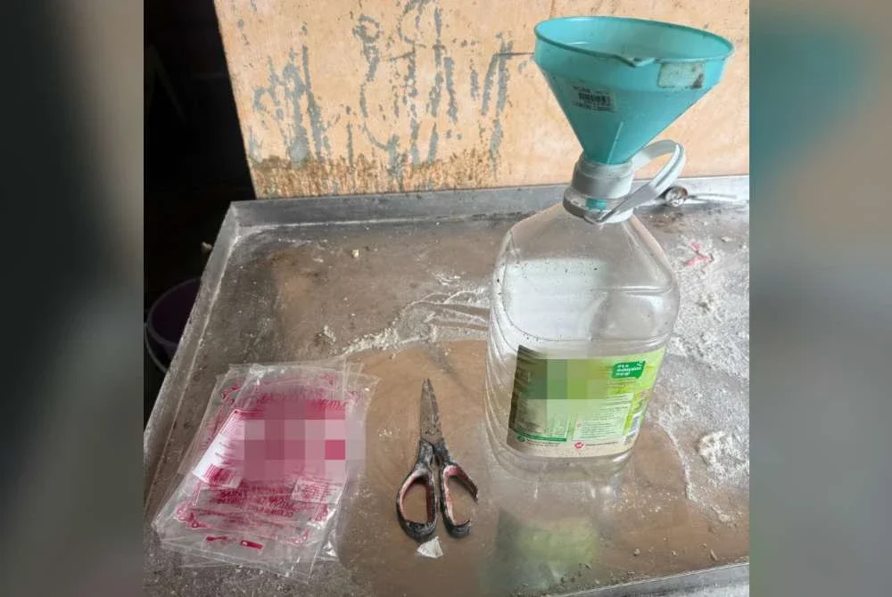 Pemilik premis menggunting peket minyak masak bersubsidi sebelum dituangkan ke dalam botol dipercayai bagi kegunaan operasi perniagaan. Foto KPDN Johor