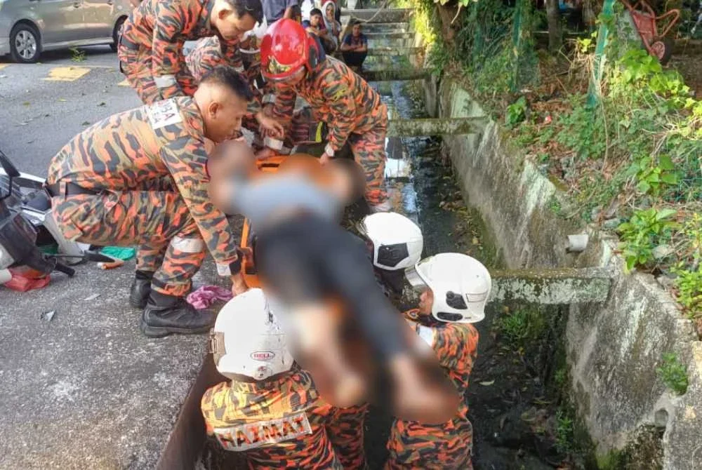 Anggota bomba membawa naik mangsa keluar dari longkang.