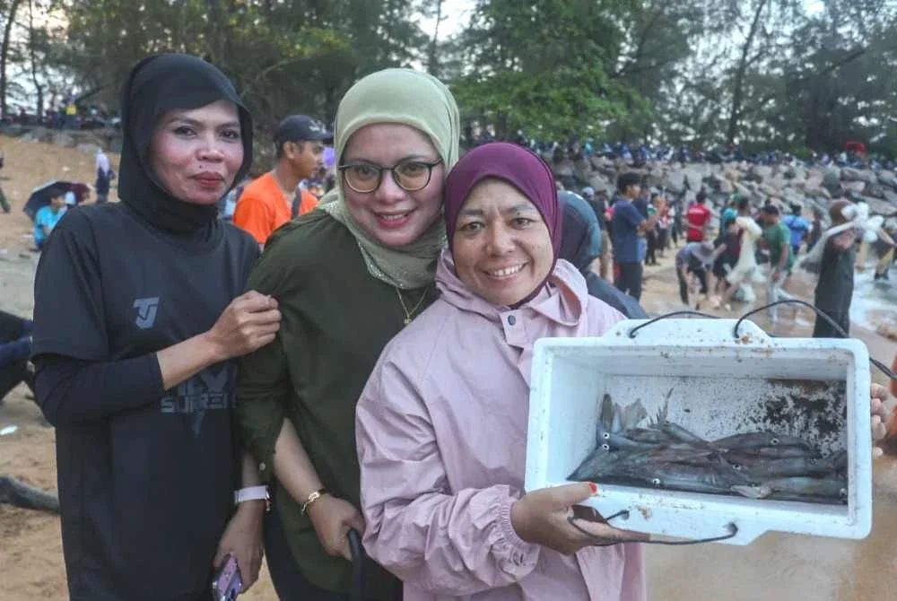 Pengunjung menunjukkan hasil sotong yang diperoleh untuk dibawa pulang.