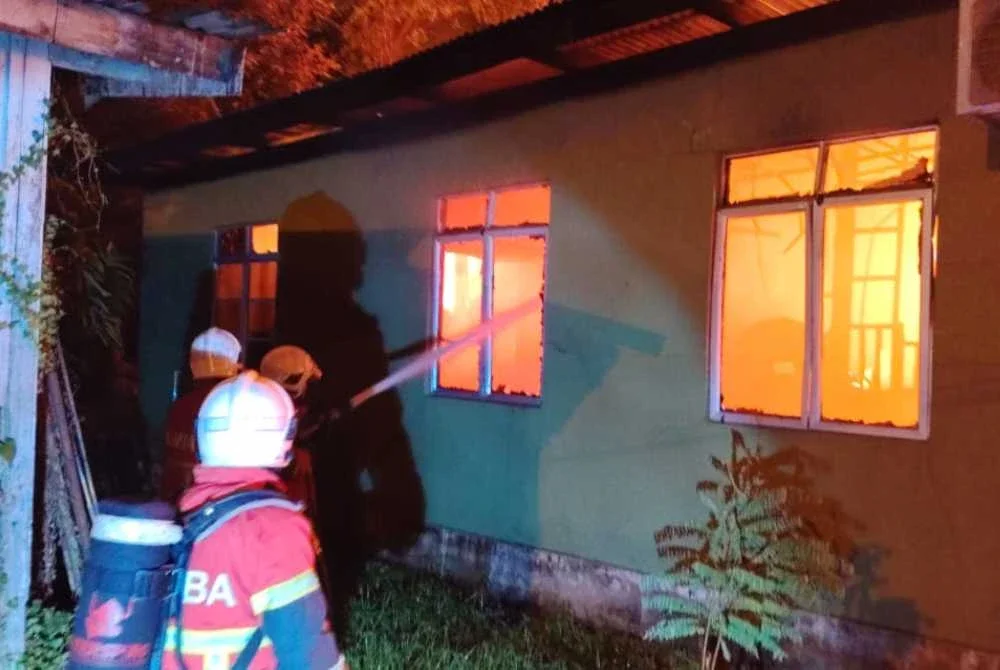 Bomba berusaha memadamkan api yang marak membakar rumah pusaka dalam kejadian di Kampung Buluh Gading, Kuala Terengganu pada Jumaat.