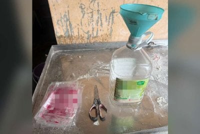 Pemilik premis menggunting peket minyak masak bersubsidi sebelum dituangkan ke dalam botol dipercayai bagi kegunaan operasi perniagaan. Foto KPDN Johor