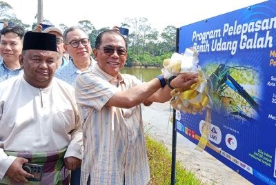 Mohamed Khaled (kanan) merasmikan Majlis Pelepasan Benih Udang Galah di Sungai Gembut, Tanjung Sedeli, Kota Tinggi pada Sabtu.