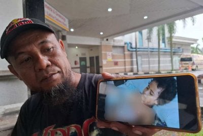 Abdul Ghafar menunjukkan keadaan anaknya yang sehingga kini masih menerima rawatan di Hospital Taiping.