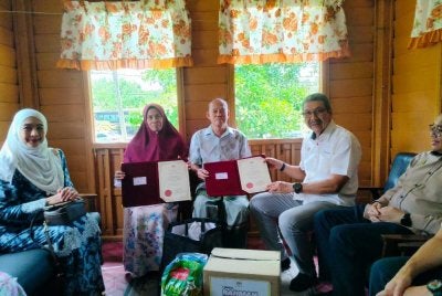 Wan Ahmad Dahlan (dua dari kanan) menyampaikan sijil penghargaan kepada pasangan pesara, Adnan Md Yusof, 74, dan Fatimah Abdul Razak, 69, ketika Program Ziarah Cakna Sentuhan Kasih sempena Program Kampung dan Sekolah Angkat Madani JPA 2026 di Kampung Kota Bharu di sini pada Sabtu.