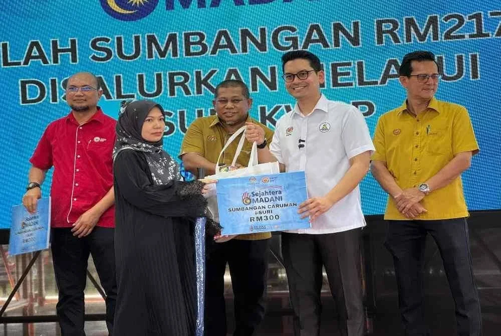 Mohammed Taufiq menyerahkn sumbangan kepada penerima di Program Kampung Angkat Madani pada Ahad.