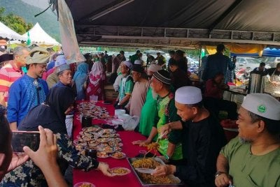 Hafez (dua dari kiri) melawat gerai makanan sambil beramah mesra bersama orang ramai yang hadir ke majlis Rumah Terbuka Aidilfitri ADUN Manjoi di Meru Raya, di sini pada Ahad.