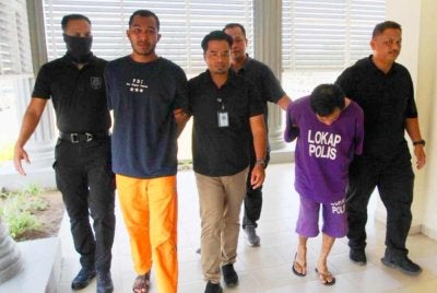 Bekas penyerang Kelantan FA (kanan, baju lokap ungu) bersama seorang rakan (kiri, seluar lokap oren) dihadapkan ke Mahkamah Sesyen pada Ahad atas pertuduhan melarikan seorang pemilik kedai emas dalam kejadian di Kampung Palekbang, Tumpat tahun lalu.