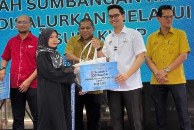 Mohammed Taufiq menyerahkn sumbangan kepada penerima di Program Kampung Angkat Madani pada Ahad.