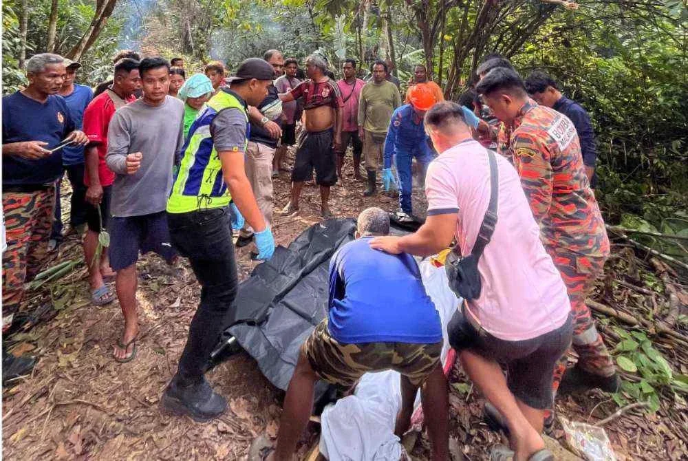 Anggota bomba dan APM membantu mengangkat mayat mangsa untuk dibawa ke hospital menggunakan kenderaan polis.