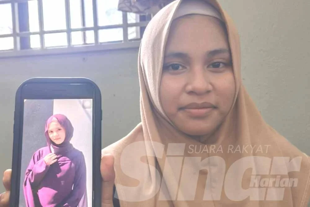 Nur Fatimatul Zahra menunjukkan gambar arwah adiknya, Nur Fatimatul Hawa ketika ditemui di rumahnya di Kampung Gayong, Kota Bharu pada Isnin.
