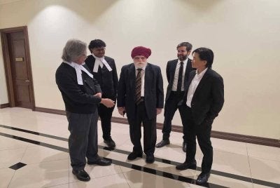 Dr Bhupinder (tengah) bersama Ram (kiri) dan rakan sepasukannya tiba di Mahkamah Koroner, Kota Kinabalu pada Isnin. 