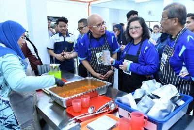 Ketua Pengarah Jabatan Pendidikan Tinggi, Profesor Datuk Dr Azlinda Azman, Pengerusi Lembaga Pengarah Universiti (LPU), Tan Sri Dr Mazlan Yusoff dan Naib Canselor UUM, Profesor Dr Ahmad Martadha Mohamed, memantau proses pembungkusan produk Dapur Siswa MADANI@UUM di UUM pada 11 April 2026.