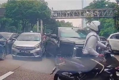 Tangkap layar video tular memaparkan sepasukan anggota trafik dipercayai menahan pemandu kereta Perodua Axia.
