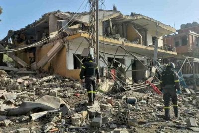 Pasukan penyelamat berkumpul di lokasi serangan udara Israel yang menyasarkan sebuah kawasan kejiranan di kampung Kfar Roummane, selatan Lubnan pada 13 April 2026. Foto: AFP