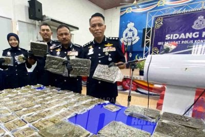 Mohd Yusoff (dua dari kanan) menunjukkan ganja yang dirampas di Kampung Banggol Kulim, Rantau Panjang pada Sabtu.