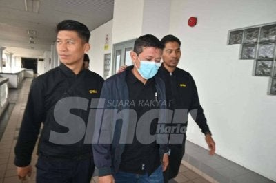 Tertuduh (tengah) mengaku tidak bersalah terhadap dua pertuduhan ke atasnya. 