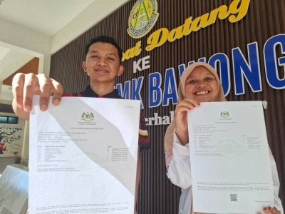 Nirzarkri (kiri) dan Mek Sofia membuktikan akses kepada bahan pembelajaran berkualiti seperti buku rujukan tambahan TCS mampu menjadi pemangkin kepada perubahan prestasi pelajar.