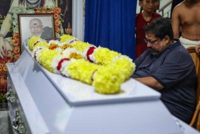 Dr Ananda Raj sebak ketika memberi penghormatan kepada mendiang bapanya di kediaman mendiang dekat Gelugor pada Selasa. Foto Bernama