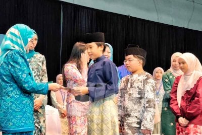 Tunku Azizah menyampaikan sampul raya kepada pelajar pada majlis hari terbuka sambutan hari raya dan taklimat pihak berkepentingan di institusi berkenaan di sini pada Rabu.