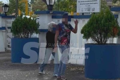 Pemandu bas ekspres yang tular bersama seorang wanita duduk di atas ribanya ketika memandu tampil ke Ibu Pejabat Polis Daerah (IPD) Jasin pada Rabu