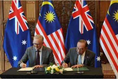 Anwar (kanan) bersama rakan sejawatnya dari Australia, Anthony Albanese menandatangani kenyataan bersama berkaitan jaminan bekalan tenaga selepas sambutan rasmi di Kompleks Perdana Putra, hari ini. - Foto: Bernama