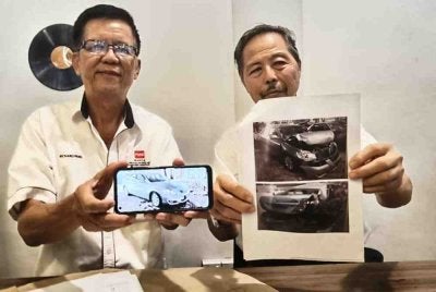 Kim Fok (kiri) dan Frankie menunjukkan gambar membuktikan kereta Toyota Camry yang dibeli pernah terlibat kemalangan serius.