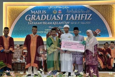 Mohd Nassuruddin (tengah) menyampaikan Anugerah Khas Syahadah 30 Juzuk kepada Ahmad Fikri Abdul Hisham (dua dari kanan) sambil ditemani ibu bapa pelajar. FOTO SINAR HARIAN - ADILA SHARINNI WAHID