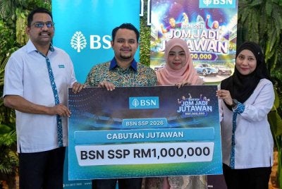 Pemangku Pengarah Bank Simpanan Nasional (BSN) Terengganu, Mohamad Kabir Ali (kiri) menyapaikan replika cek kepada Pegawai Tadbir Negeri Kelantan, Muhammad Riyadhul Hanif Abdullah, 34, (dua, kiri) yang ditemani isteri Zarifah Zulkepli, 33, (dua, kanan) selepas dinobat sebagai pemenang cabutan Jutawan Bank Simpanan Nasional Sijil Simpanan Premium (BSN SSP) pada Program Temu Ramah Media Bersama Pemenang BSN SSP Ke-122 hari ini. Foto Bernama 