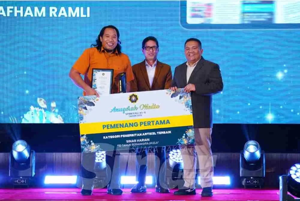 Muhammad Afham (kiri) menerima anugerah tempat pertama kategori Penerbitan Artikel Terbaik. Foto MOHD HALIM ABDUL WAHID