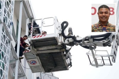Seorang mangsa diselamatkan menggunakan jentera aerial ladder platform dari tingkat empat salah sebuah blok bangunan terlibat. Gambar kecil: Mohd Syarim