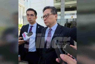 Rizwandean (kanan) bersama rakan sepasukannya Mohd Syarulnizam ketika ditemui pemberita di pekarangan Kompleks Mahkamah Kota Kinabalu.