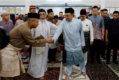 Anwar beramah mesra dengan jemaah selepas menunaikan solat Jumaat di Surau Bomba Cyberjaya hari ini. Foto Bernama