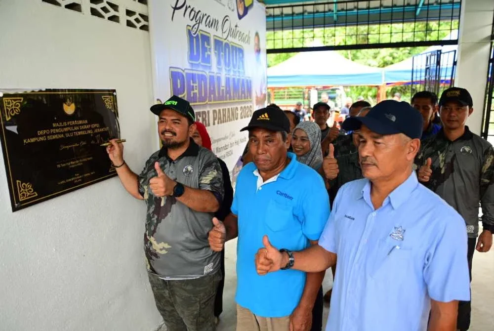 Manndzri (kiri) menandatangani plak simbolik merasmikan Depo Pengumpulan Skrap (DPS) Kampung Semena, Ulu Tembeling, Jerantut.