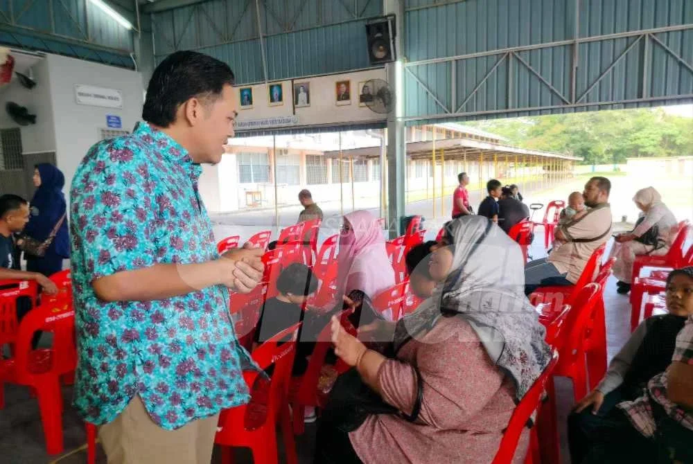 Mohamad Hairul Amir (kiri) bertemu dengan waris pelajar selepas menyempurnakan Program Bantuan Pendidikan Madani Parlimen Tambun 2026 di SMK Ulu Kinta pada Sabtu.