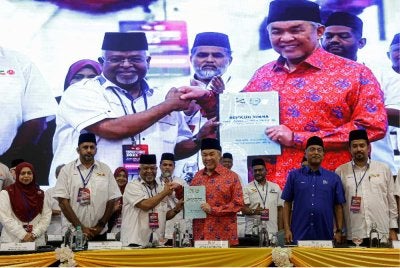 Ahmad Zahid (tengah) bersama Syed Ibrahim menunjukkan Buku Resolusi KIMMA pada Perhimpunan Agung KIMMA kali ke-46 tahun 2025 di WTCKL pada Sabtu. Foto: Bernama