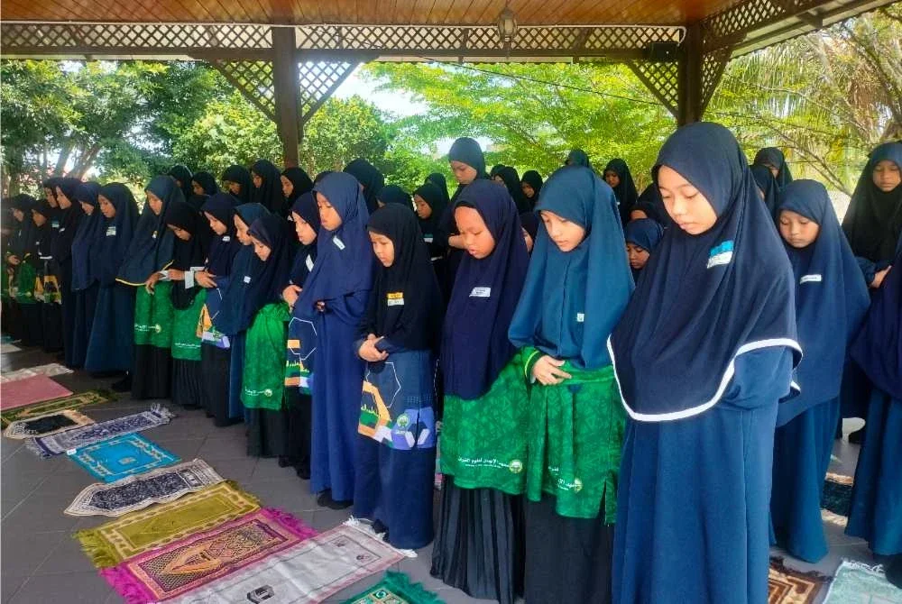 Murid sekolah rendah solat berjemaah sebelum pulang selepas tamat sesi persekolahan harian.