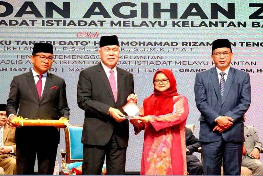 Tengku Mohamad Rizam (dua,kiri) menyampaikan apresiasi media MAIK kepada Ketua Biro Sinar Harian Kelantan, Hazelen Liana Kamarudin pada Majlis Sidang Media Laporan Khas Kutipan dan Agihan Zakat MAIK Bagi Tahun 2025 di Kota Bharu pada Ahad.
