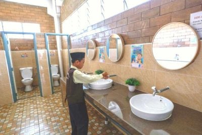 Penglibatan pelajar secara langsung dalam menjaga kebersihan fasiliti awam seperti tandas sekolah dapat memupuk rasa tanggungjawab bersama. - FOTO: Bernama 
