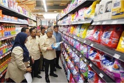 Ahmad Zahid diiringi Manndzri melihat produk dijual di RisSMart Grocer selepas majlis perasmian pada Ahad - Foto: SINAR HARIAN / ROSLI TALIB
