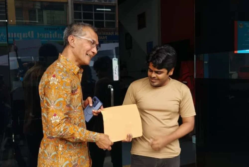 Faizan (kiri) menyerahkan memorandum bagi menggesa Rafizi berundur daripada dunia politik.