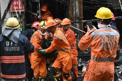 Anggota Pasukan Tindak Balas Bencana Kebangsaan (NDRF) mengusung mayat mangsa selepas kebakaran berlaku di sebuah bangunan kediaman di New Delhi pada 18 Mac 2026. Foto AFP