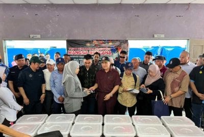 Hajiji menyampaikan bantuan awal kepada mangsa kebakaran di Kampung Bahagia, Batu Sapi, Sandakan pada Isnin. 